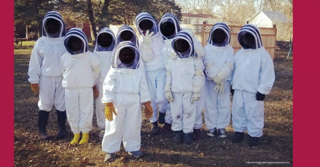 Ten student beekeepers in white beekeeping suits with black veils. 